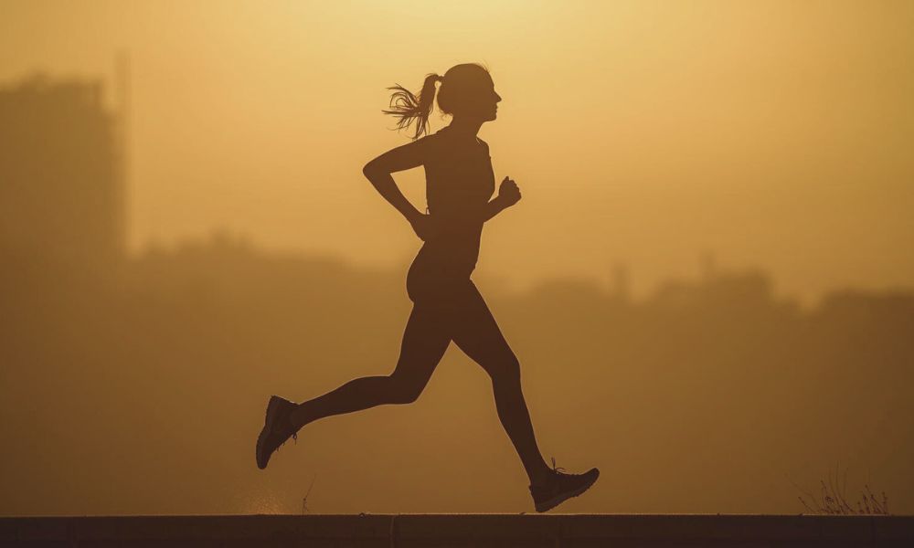A runner in rhythmic motion during golden hour, illustrating running meditation.