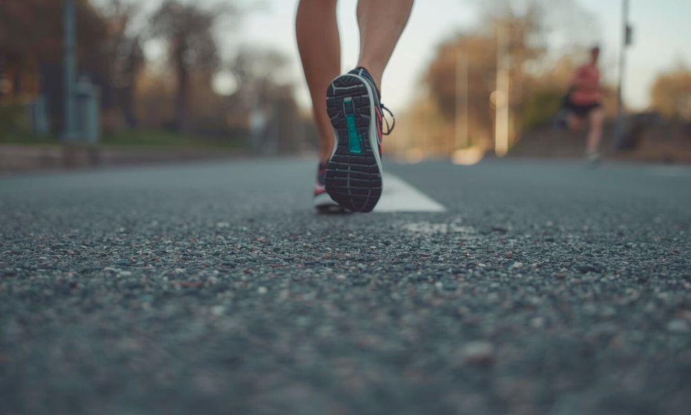 Feet in motion on a silent road, highlighting the benefit of running alone.
